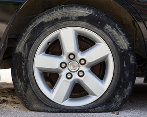 Flat tire on a car beside the road