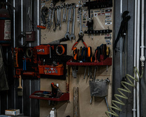 Well-organized garage workshop with tools neatly hanging on walls and workbench set up for spring projects