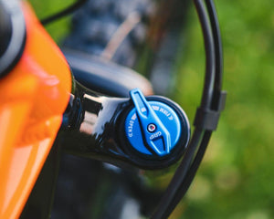 Close-up of mountain bike front suspension fork with blue compression adjustment knob